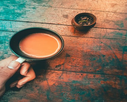 A glass of water and Indian chai on a table